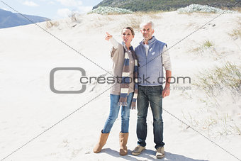 Attractive couple standing holding hands on the beach