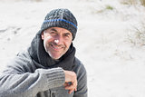 Attractive man smiling on the beach in hat and scarf