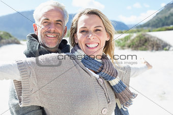 Carefree couple standing on the beach in warm clothing
