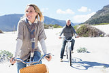 Carefree couple going on a bike ride on the beach