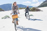 Carefree couple going on a bike ride on the beach