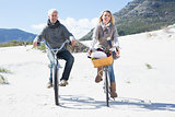 Carefree couple going for a bike ride and picnic on the beach