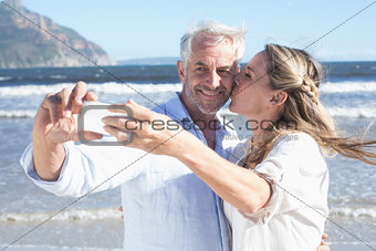 Married couple at the beach together taking a selfie