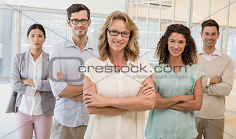 Casual business team smiling at camera with arms crossed