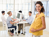 Casual pregnant businesswoman smiling at camera