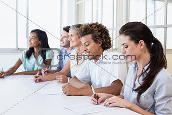 Casual business team taking notes in meeting