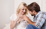 Young couple sitting on floor drinking wine