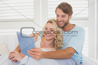 Young couple using tablet pc on the couch