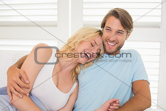 Young couple sitting on the couch laughing