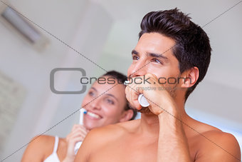 Attractive couple brushing their teeth in the morning