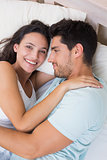 Attractive couple cuddling on bed