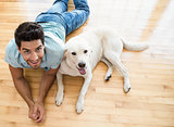 Attractive man lying on floor with his labrador