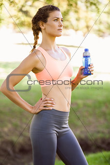 Fit woman holding water bottle in the park