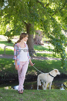 Cute blonde with her labrador dog in the park