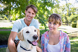 Cute couple with their labrador dog in the park