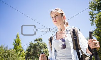 Pretty hiker with backpack walking uphill