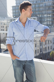 Handsome man looking over his balcony