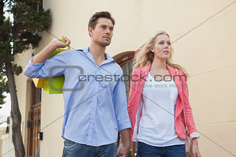 Stylish young couple walking with shopping bags