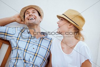 Young hip couple laughing on bench