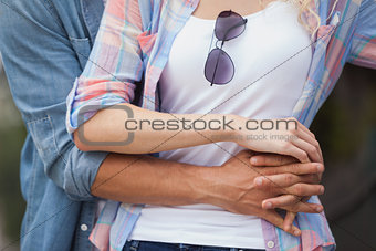 Hip young couple standing and embracing