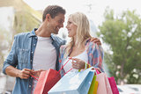 Hip young couple holding shopping bags