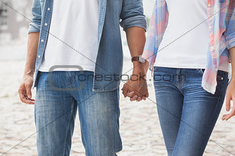 Hip young couple holding hands