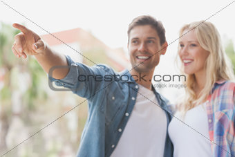 Hip young couple looking at something and pointing