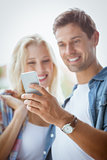 Cute young couple looking at smartphone together