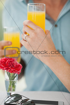Cute couple sitting in cafe drinking orange juice