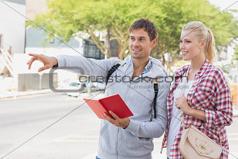 Young tourist couple consulting the guide book