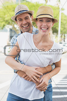 Young hip couple hugging and smiling at camera