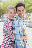 Young hip couple standing and hugging smiling at camera