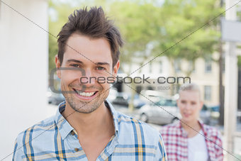 Young hip couple smiling at camera