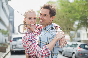 Couple in check shirts and denim hugging each other