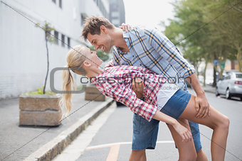 Hip romantic couple dancing in the street