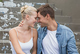 Hip young couple sitting on steps smiling at each other