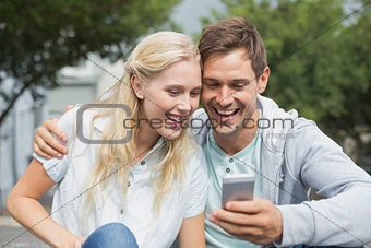 Hip young couple looking at smartphone