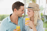 Hip young couple drinking orange juice together