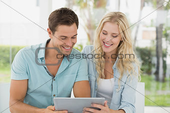 Hip young couple looking at tablet together