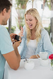 Man proposing marriage to his shocked blonde girlfriend