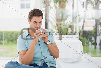 Handsome man sitting at table having coffee