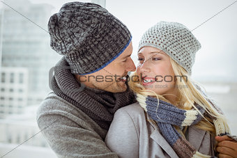 Cute couple in warm clothing smiling at each other