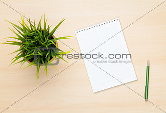 Blank notepad, pen and flower on wooden table