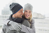 Cute couple in warm clothing hugging woman smiling at camera