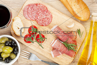 Red wine with cheese, prosciutto, bread, vegetables and spices