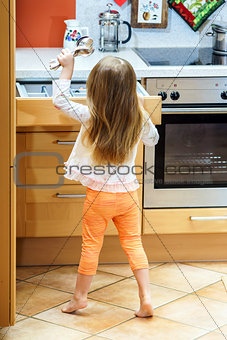 Little girl getting tableware before dinner