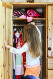 Cute little girl hanging up her clothes