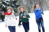 Three girls run on the forest path