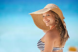 Portrait of woman with straw hat at beach smiling
