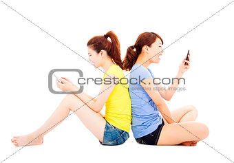 two happy pretty girls playing smart phone
